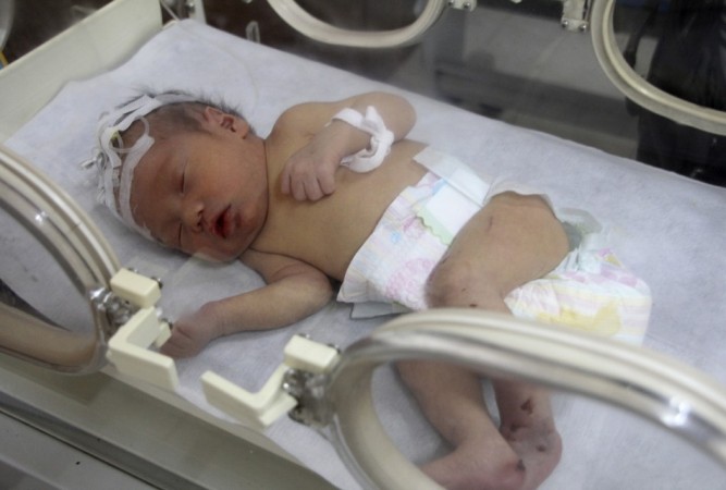 Firefighters and doctors rescue an abandoned newborn baby boy by cutting away a sewage pipe piece by piece, in this still image taken from video, in Jinhua city, Zhejiang province May 25, 2013 (Reuters) Chinese Newborn baby