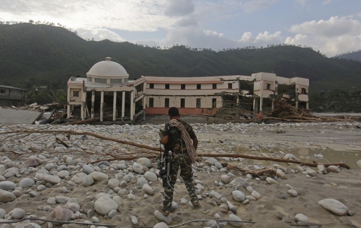 A member of the rescue operation team of Sashastra Seema Bal (SSB) or Armed Border Force walks towards the officers training centre damaged by floods at their campus in Srinagar in the Himalayan state of Uttarakhand. (Reuters) North India