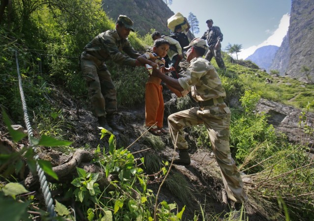 A child is carried by soldiers to help him climb down a hill during a rescue operation at Govindghat in the Himalayan state of Uttarakhand June 21, 2013. (Reuters) North India Floods