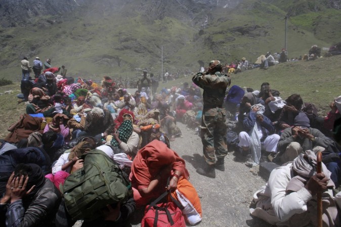 People and soldiers cover their faces as an army helicopter lands during rescue operations at Badrinath in the Himalayan state of Uttarakhand June 21, 2013. (Reuters) North India Floods