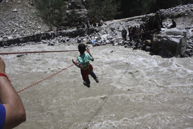 Indian Army personnel rescue a stranded child with the help of ropes through the flooded waters of a river in the Himalayan state of Uttarakhand(Reuters) Indian Army personnel rescue a stranded child with the help of ropes through the flooded waters of a river in the Himalayan state of Uttarakhand(Reuters)