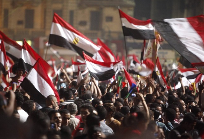 Anti-Mursi protesters walk with their flags as they celebrate in Tahrir square after the announcement of the removal from office of Egypt's deposed President Mohamed Mursi Egypt
