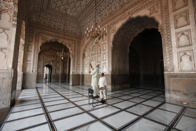 A worker cleans a chandelier inside the Badshahi Mosque ahead of the holy month of Ramadan in Lahore, July 9, 2013. REUTERS/Mohsin Raza Ramadan
