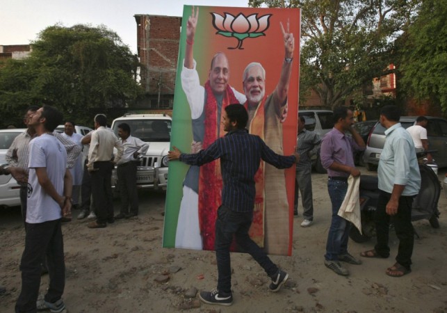 An activist of the BJP carries a hoarding showing Narendra Modi and Rajnath Singh in Jammu BJP supporter