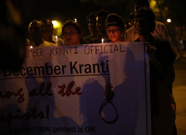 Demonstrators carry a banner during a candle light vigil after four men convicted of raping and murdering a 23-year-old woman in Delhi were sentenced to death in New Delhi Delhi gang-rape case