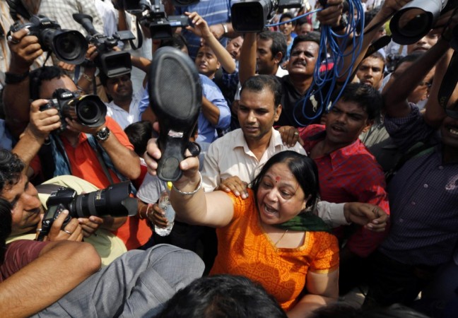 A protester threatens to throw her sandal at A.P. Singh outside a court in New Delhi Delhi gang-rape case