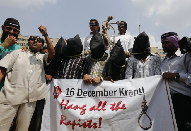 Demonstrators with their heads covered by black cloth take part in a protest outside a court in New Delhi Delhi gang-rape case