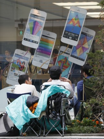 Men sitting on folding chairs wait for selling new iPhone 5s, which will be on sale on September 20, in front of an Apple Store in Tokyo iPhone 5s