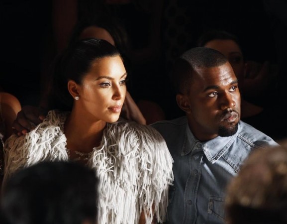 Kanye West drapes his arm over the shoulder of Kim Kardashian as they watch a showing of the Marchesa Spring/Summer 2013 collection during New York Fashion Week, September 12, 2012. Kim Kardashian, Kanye West