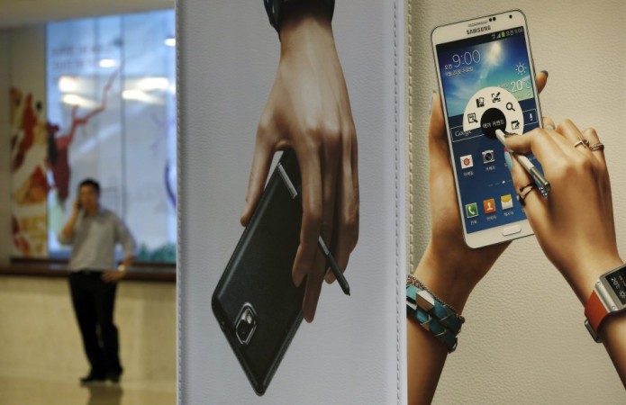 A man talks on his mobile phone near advertisements promoting the Samsung Electronics' Galaxy Note 3 at the company's headquarters in Seoul October 21, 2013. Picture taken October 21, 2013. REUTERS/Kim Hong-Ji Samsung Galaxy Note 3
