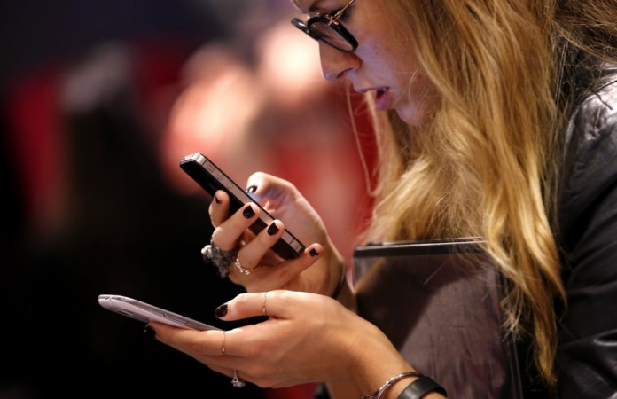 A consumer checks out smartphones (Reuters) A consumer checks out smartphones (Reuters)