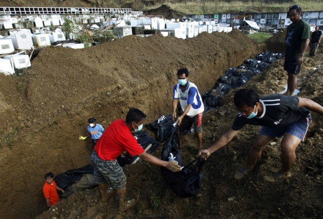 People carry a body bag to a mass grave for burial in the aftermath of super typhoon Haiyan in Tacloban Typhoon Haiyan