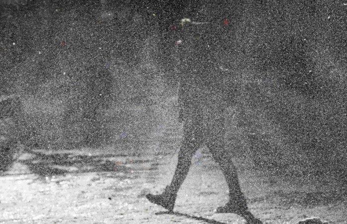 A woman walks through a gust of blowing snow in frigid cold temperatures during winter in downtown Chicago, Illinois, January 6, 2014.