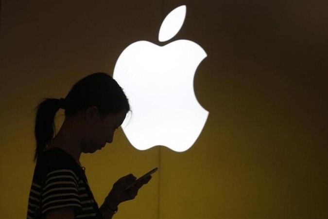 A woman looks at the screen of her mobile phone in front of an Apple logo outside its store in downtown Shanghai September 10, 2013. A woman looks at the screen of her mobile phone in front of an Apple logo outside its store in downtown Shanghai September 10, 2013.