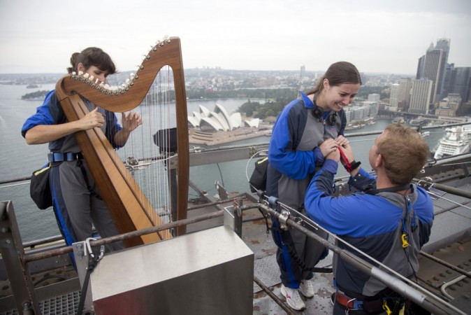 Lucas Farrell (R) proposes to his girlfriend Natalie Rumble as Irish-born harpist Cliona Molins plays a romantic tune at the top of the Sydney Harbour Bridge on Valentines Day, February 14, 2014. (Reuters) Valentine's Day