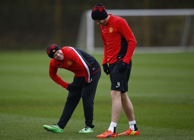 Manchester United players Wayne Rooney and Michael Carrick share a laugh during a training session ahead of their Champions League encounter against Olympiakos, 24 February. Reuters Wayne Rooney Michael Carrick Manchester United