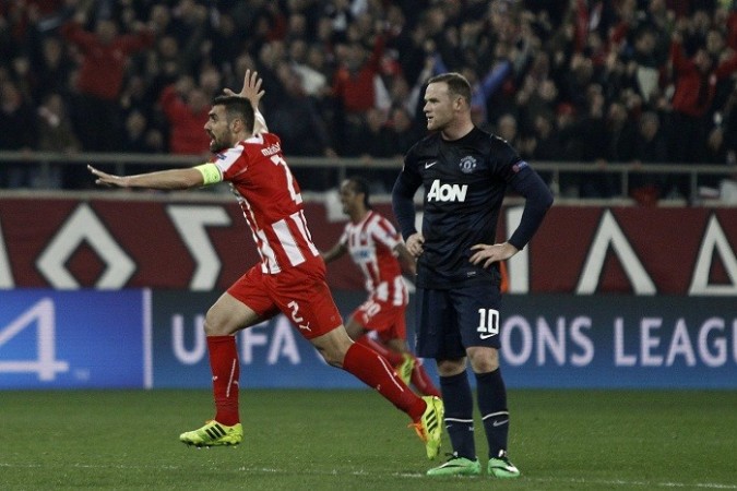 Giannis Maniatis celebrates an Olympiakos goal as Manchester United forward Wayne Rooney looks on in despair during their Champions League first leg game, 25 February. Reuters Maniatis Olympiakos Wayne Rooney Manchester United