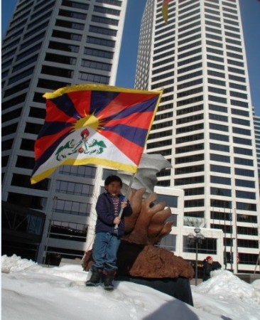 A Tibetan child waves the Tibetan national flag in front of a Twin-tower in Minneapolis, Minnesota, U.S.A. (Photo Credit: Tendar Tsering) A Tibetan child waves the Tibetan national flag in front of a Twin-tower in Minneapolis, Minnesota, U.S.A. (Photo Credit: Tendar Tsering)