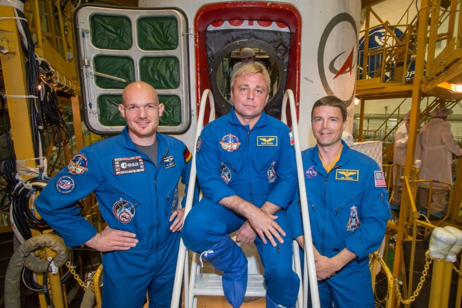 At the Baikonur Cosmodrome in Kazakhstan, Expedition 40 Flight Engineers Alexander Gerst (left), Maxim Suraev (center) and Reid Wiseman pose for pictures in front of their Soyuz TMA-13M spacecraft. (NASA/Victor Zelentsov)