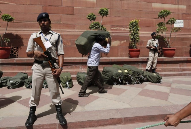 Indian security personnel stand guard near sacks containing the papers of the federal budget for the 2014, 2015 fiscal year, at the parliament in New Delhi