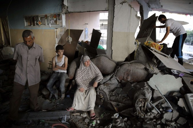A Palestinian family gathers inside their damaged home, which police said was targeted in an Israeli air strike, in Gaza City.