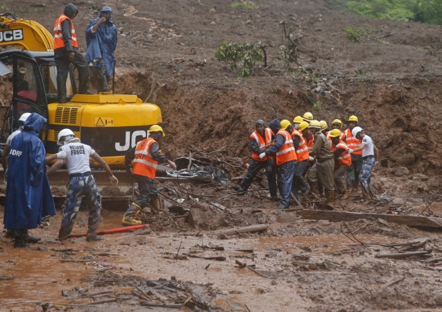 National Disaster Response Force (NDRF) personnel carry the body of a victim from the site of a landslide at Malin village, in the western Indian state of Maharashtra July 31, 2014. Pune Landslide