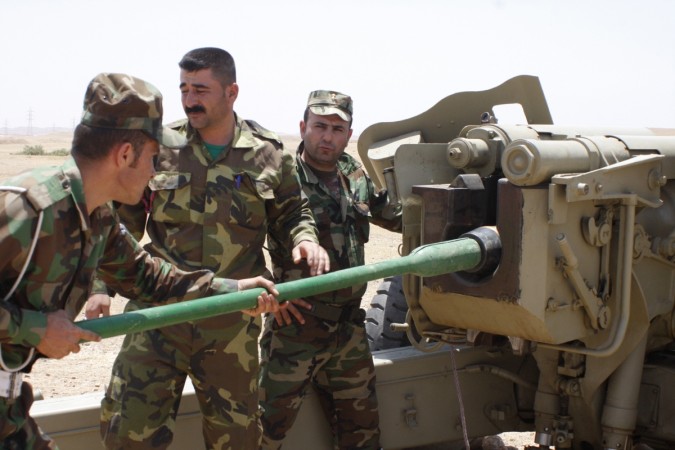 Kurdish Peshmerga troops prepare to fire a cannon during clashes with militants of the Islamic State in Iraq