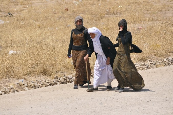 Displaced families from the minority Yazidi sect, fleeing the violence, walk on the outskirts of Sinjar, west of Mosul, 5 August.