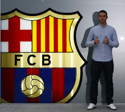 Thomas Vermaelen poses next to a club logo after his arrival at FC Barcelona's offices. Thomas Vermaelen