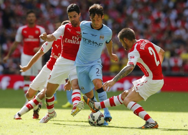 David Silva is tackled by Arsenal's Mikel Arteta and Mathieu Debuchy during their Community Shield tie David Silva