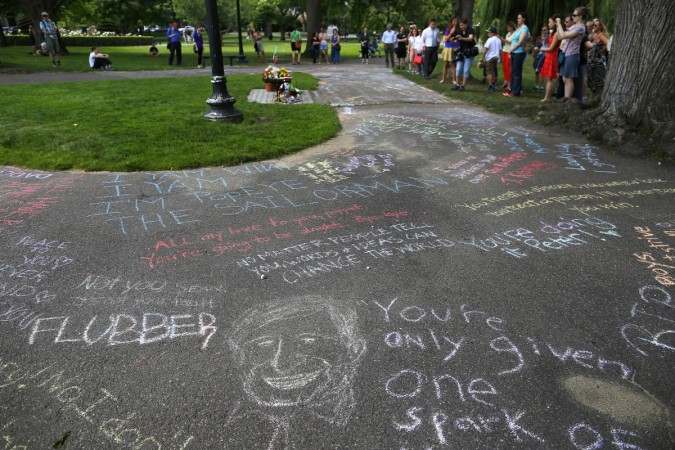 Fans write quotes on the sidewalk of the Public Garden in Boston, Massachusetts, where a scene of film Robin Williams Demise