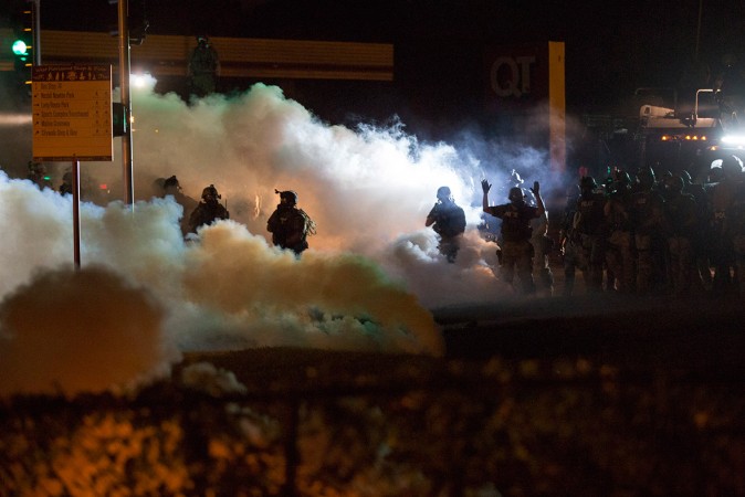Riot police clear a street with smoke bombs while clashing with demonstrators in Ferguson Riot police clear a street with smoke bombs while clashing with demonstrators in Ferguson