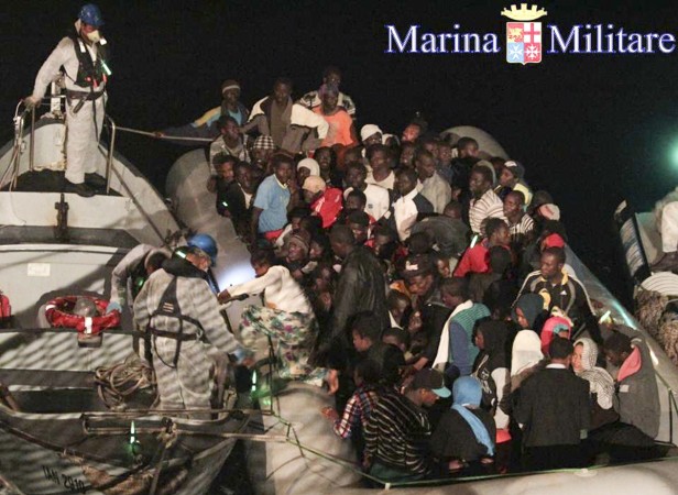 Migrants sit in their boat during a rescue operation by Italian navy ship Scirocco about 40 nautical miles off the coast of Libya in this handout picture released on June 14, 2014 by the Italian Marina Militare. Migrants sit in their boat during a rescue operation by Italian navy ship Scirocco about 40 nautical miles off the coast of Libya in this handout picture released on June 14, 2014 by the Italian Marina Militare.