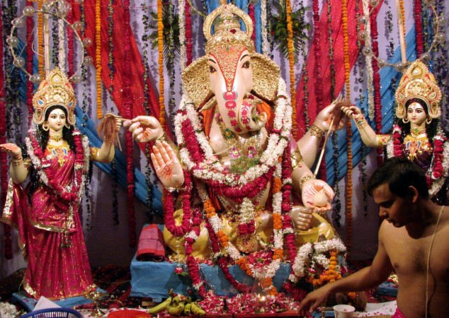 A Hindu priest performs prayers in front of a Ganesh idol at a pandal or makeshift stage.The whole community comes to worship Ganesh in these beautifully decorated tents, which often serve as a venues for free medical check-ups, blood donation camps, charity for the poor, dramatic performances and singing devotional songs during the 10 spiritual days of the festival. Ganesh Chaturthi Pandal