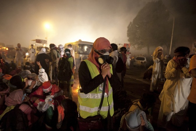 Anti-government protesters trying to protect themselves from tear gas released by the police. Pakistan crisis