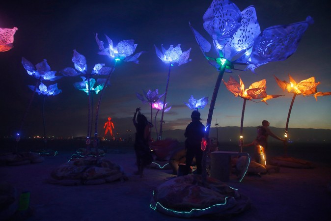 Festival-goers move around the art installation Pulse & Bloom after it is illuminated as night falls in the Black Rock Desert of Nevada. Festival-goers move around the art installation Pulse & Bloom after it is illuminated as night falls in the Black Rock Desert of Nevada.
