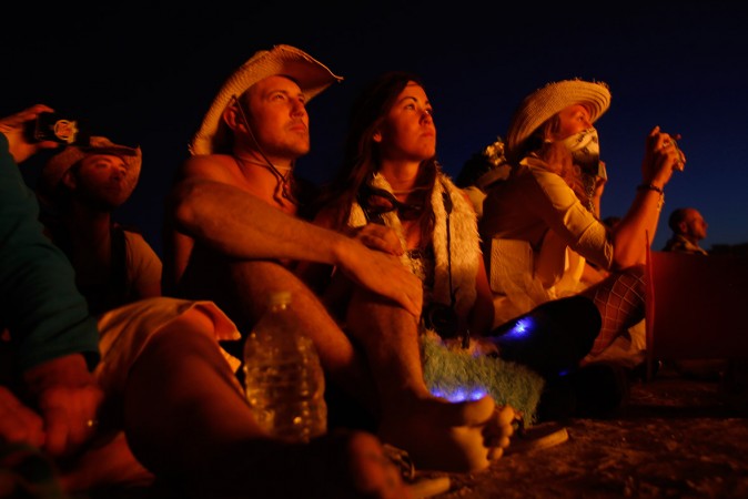 Festival-goers watch as the effigy of The Burning Man lights up after the fireworks Festival-goers watch as the effigy of The Burning man lights up after the fireworks