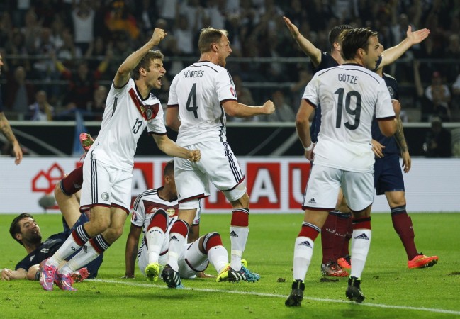 Germany's Thomas Mueller (L), Benedikt Hoewedes and Mario Goetze (R) celebrate after Mueller scored their second goal against Scotland during their Euro 2016 qualifying match in Dortmund Germany