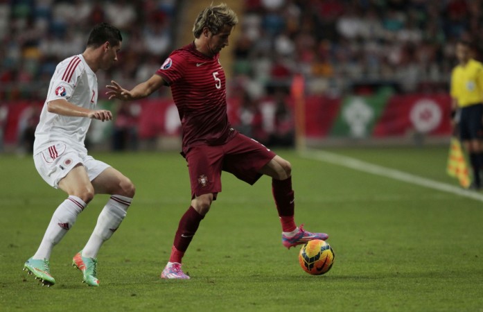 Portugal's Fabio Coentrao (R) fights for the ball with Albania's Odise Roshi during their Euro 2016 qualifying soccer match at the Aveiro city stadium in Aveiro Portugal
