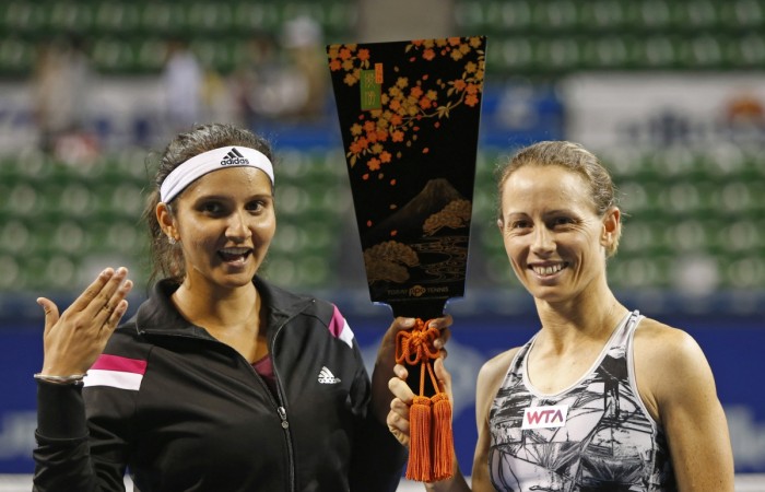 Cara Black (R) of Zimbabwe and Sania Mirza of India hold their trophy, a traditional Japanese battledore, as they pose for photographs after defeating Garbine Muguruza and Carla Suarez Navarro of Spain in their Pan Pacific Open women's doubles final. Sania Mirza
