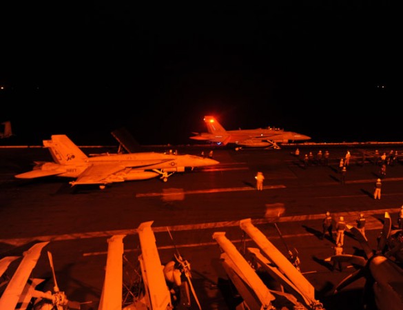 An F/A-18E Super Hornet, attached to Strike Fighter Squadron (VFA) 31, and an F/A-18F Super Hornet, attached to Strike Fighter Squadron (VFA) 213, prepare to launch from the flight deck of the aircraft carrier USS George H.W. Bush (CVN 77) to conduct stri