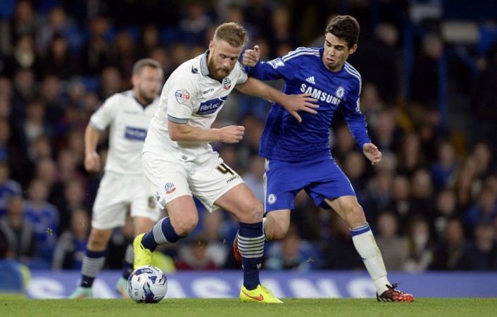 Bolton Wanderers' Matt Mills fights for the ball with Chelsea's Oscar (R) during the English League Cup soccer match at Stamford Bridge in London Chelsea