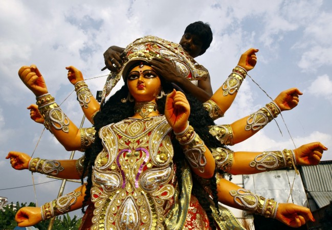 A man adorns an idol of the Hindu goddess Durga before it is taken to a pandal ahead of the Durga Puja festival in Kolkata. Durga Puja 2014