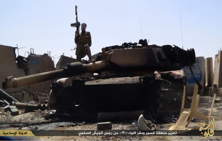 An ISIS fighter atop a destroyed tank after taking over an army camp in the Anbar province near Fallujah. ISIS has released the pictures of its attack on Iraq 30th brigade,in which over 300 Iraqi soldiers were killed.