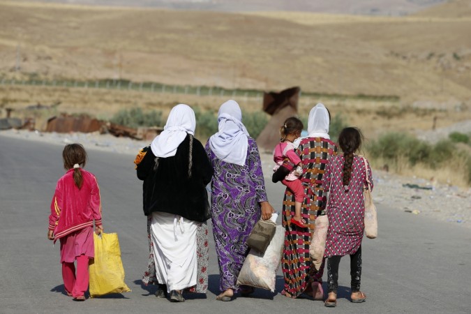 The hardliner Sunni Militants, Islamic State (ISIS) tried to give a justification for capturing thousands of Yazidi women. (Photo: Women and children from the minority Yazidi sect, fleeing the violence in the Iraqi town of Sinjar, walk to a refugee camp after they re-entered Iraq from Syria at the Iraqi-Syrian border crossing in Fishkhabour, Dohuk province, August 14, 2014.) The hardliner Sunni Militants, Islamic State (ISIS) tried to give a justification for capturing thousands of Yazidi woman.
