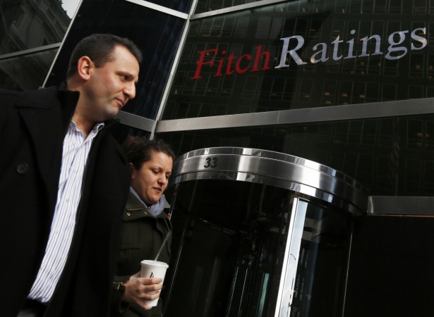 People walk past the headquarters of Fitch Ratings in New York on 6 February 2013. Fitch rating