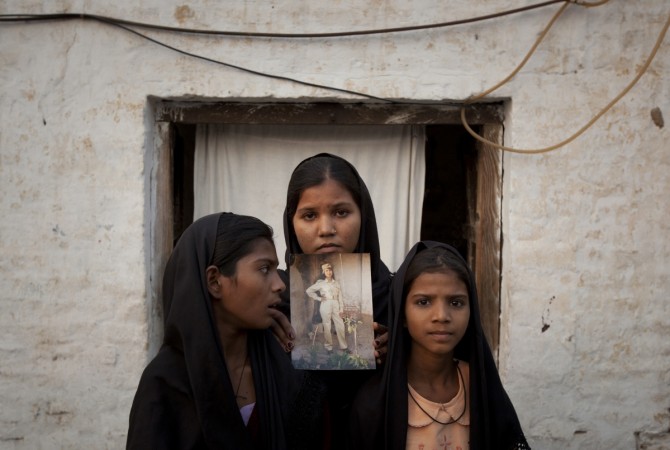 The daughters of Pakistani Christian woman Asia Bibi pose with an image of their mother outside their residence in Sheikhupura located in Pakistan's Punjab Province Daughters of Pakistani Christian woman Asia Bibi