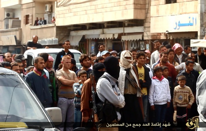 People gather to watch the beheading of three men accused by ISIS of insulting Allah in Raqqa. People gather to watch the beheading of three men accused by ISIS of insulting Allah in Raqqa.