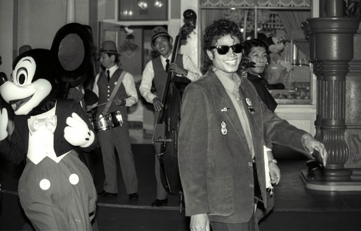Mickey Mouse follows Michael Jackson as he strolls at a shopping street at the Tokyo Disneyland during his sightseeing tour September 29, 1987 Mickey Mouse Birthday