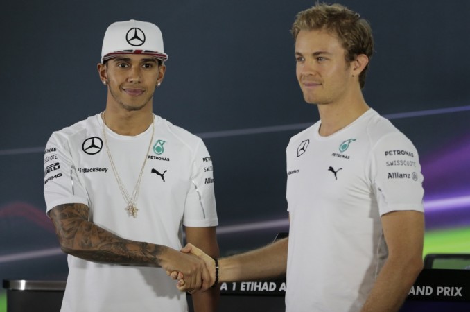 Mercedes Formula One driver Nico Rosberg (R) of Germany shakes hands with Mercedes Formula One driver Lewis Hamilton of Britain before a news conference at the Yas Marina circuit before the start of the Abu Dhabi Grand Prix November 20, 2014. Mercedes drivers Lewis Hamilton and Nico Rosburg